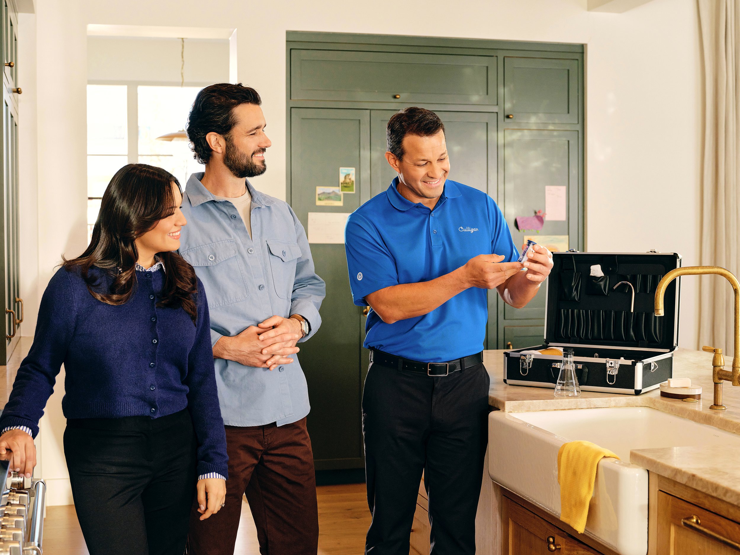 Culligan man showing couple water test kitill test your water to make sure it's clean & safe